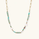 Load image into Gallery viewer, Gold chain necklace with seafoam green quartz cylinders, turquoise beads, and baroque pearl on cream background
