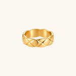 Load image into Gallery viewer, Close-up of an 18K gold-plated twisted band ring with dimensional braided pattern on cream background.