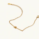 Load image into Gallery viewer, Delicate gold chain bracelet with minimalist bar and centered knot detail on cream background