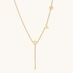 Load image into Gallery viewer, Gold Y-shaped necklace with L-O-V-E letter charms and vertical bar pendant on delicate chain against cream background