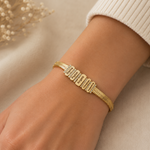 Load image into Gallery viewer, Personalized Family Name Herringbone Chain Bracelet gold-plated bracelet with rectangular engraved nameplates worn on a wrist with cream sweater cuff.