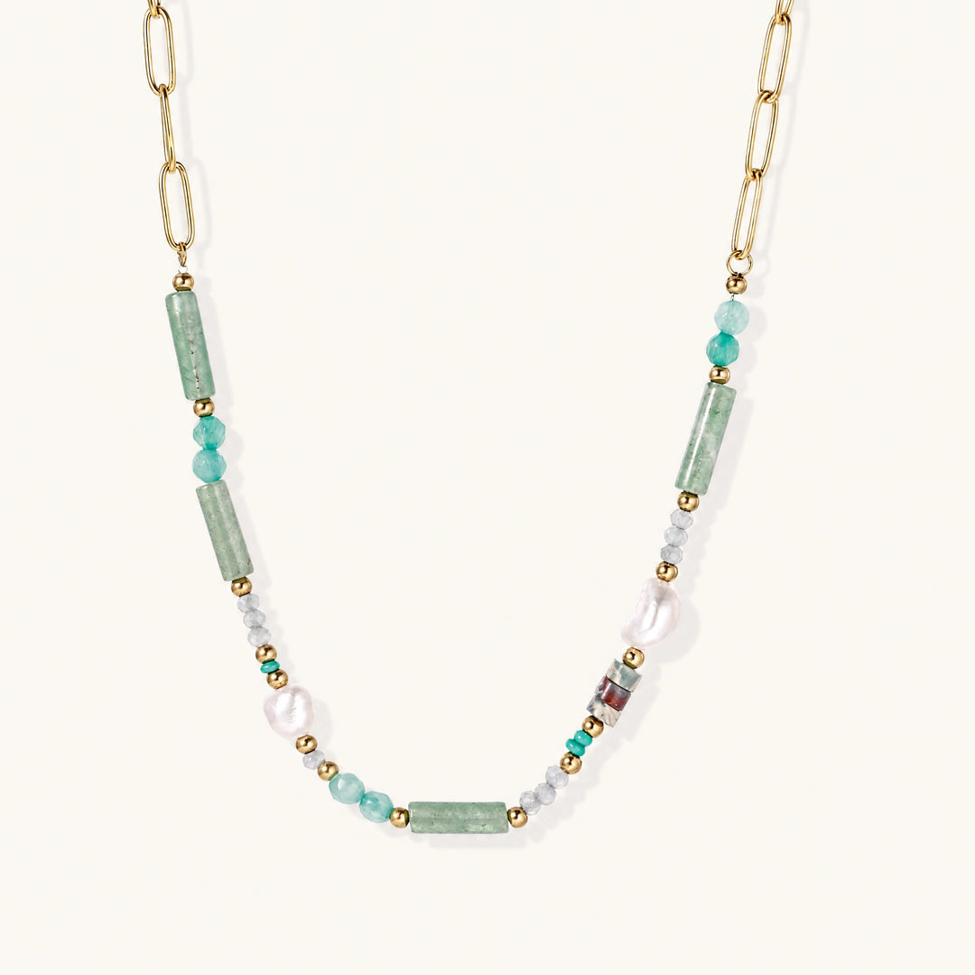 Gold chain necklace with seafoam green quartz cylinders, turquoise beads, and baroque pearl on cream background