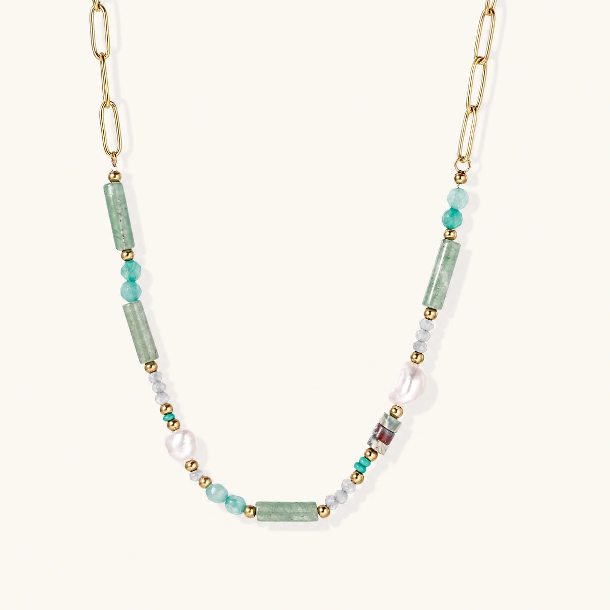 Gold chain necklace with seafoam green quartz cylinders, turquoise beads, and baroque pearl on cream background