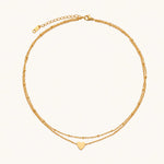 Load image into Gallery viewer, Delicate double-chain gold necklace with tiny heart pendant on cream background
