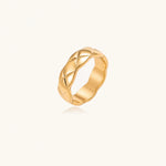 Load image into Gallery viewer, Close-up of an 18K gold-plated twisted band ring with dimensional braided pattern on cream background.
