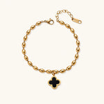 Load image into Gallery viewer, 18K gold-plated oval bead bracelet with a four-leaf clover charm in mother-of-pearl or black enamel, adjustable lobster clasp, on white background.
