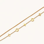 Load image into Gallery viewer, Double-layer gold-plated bracelet with quatrefoil and star charms on cream background, 18K gold finish.
