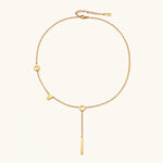 Load image into Gallery viewer, Gold Y-shaped necklace with L-O-V-E letter charms and vertical bar pendant on delicate chain against cream background
