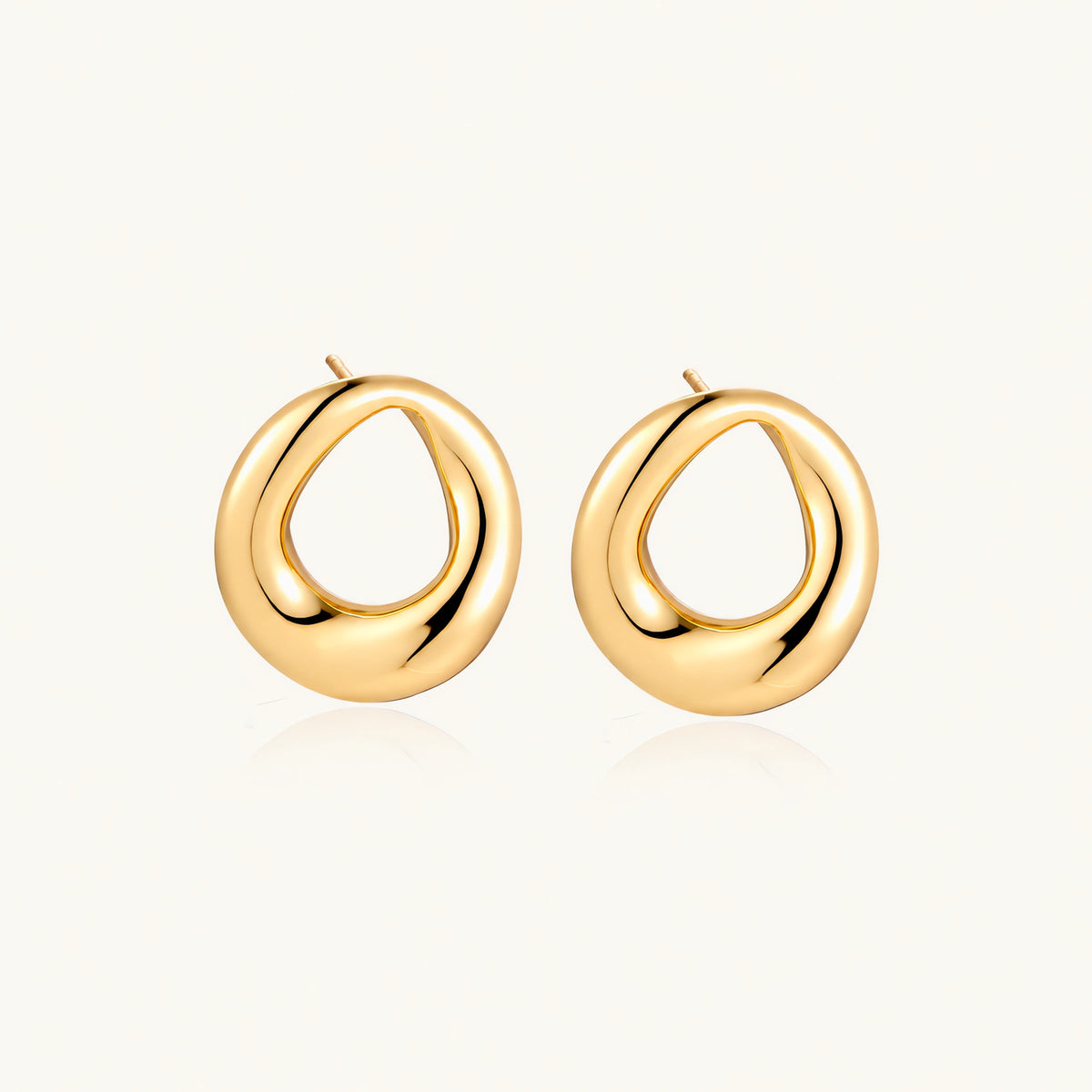 Pair of polished 18K gold-plated stainless steel teardrop earrings with hollow centers on cream background