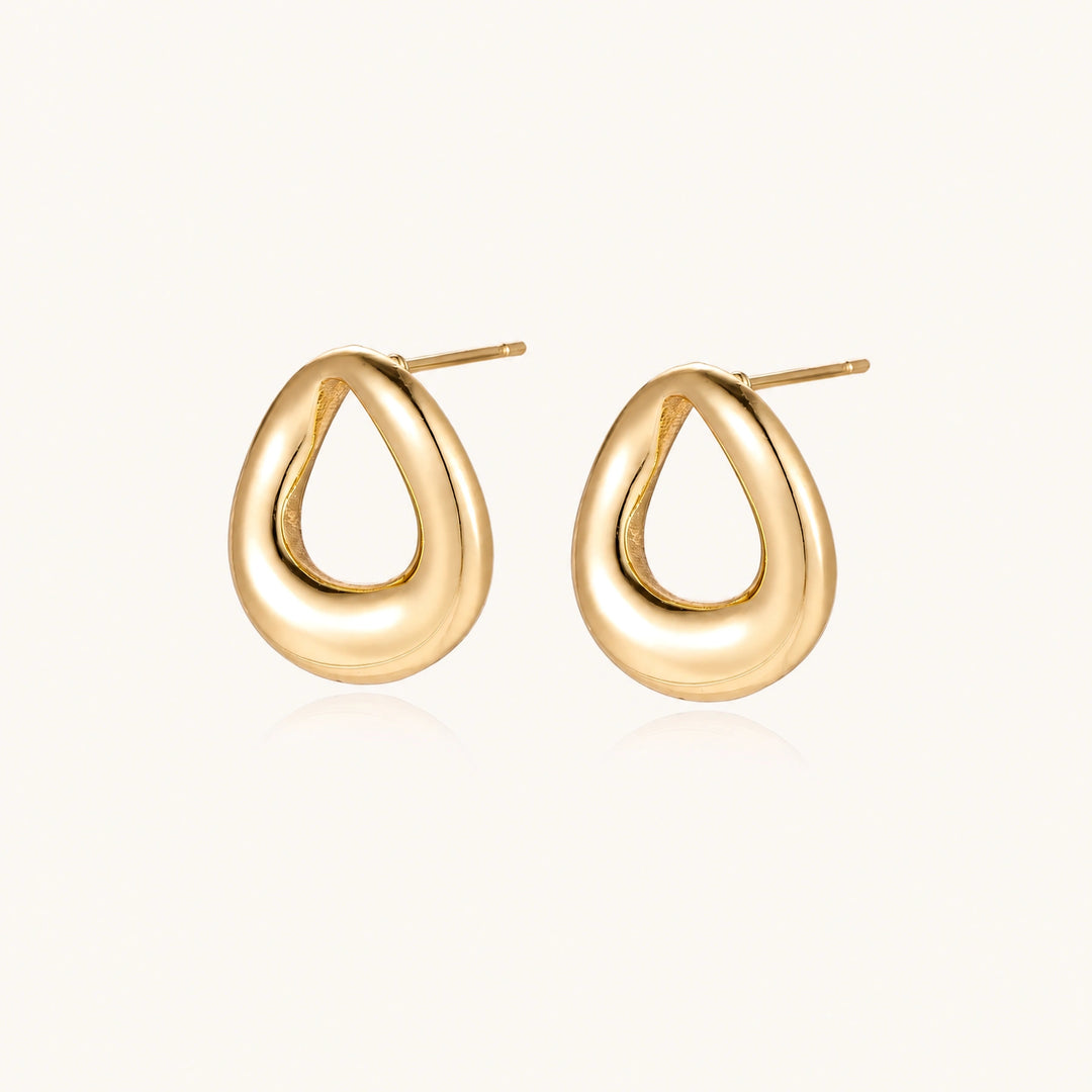Pair of polished 18K gold-plated stainless steel teardrop earrings with hollow centers on cream background