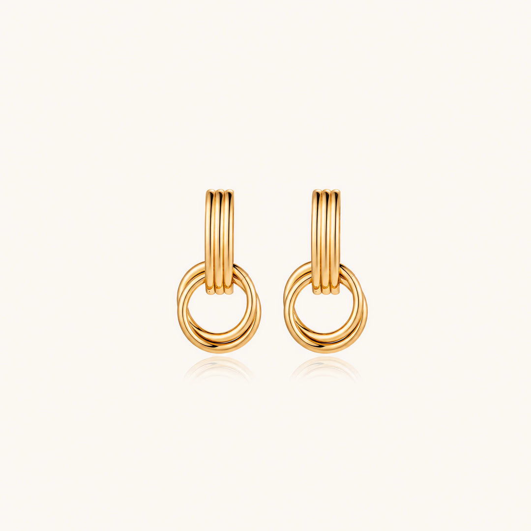 Gold stud earrings with vertical ridged bar connecting to triple interlocking circular rings on white background
