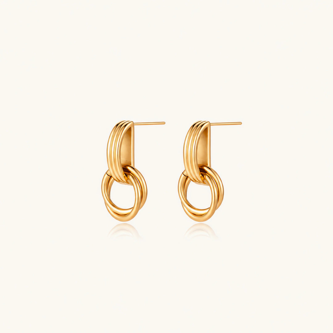 Gold stud earrings with vertical ridged bar connecting to triple interlocking circular rings on white background