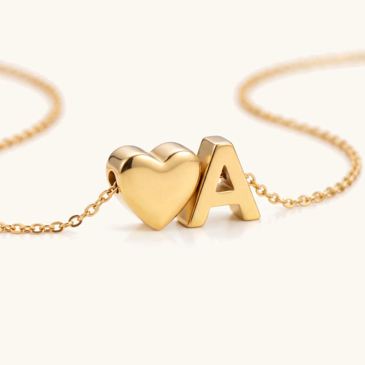 Love Letter Necklace – close-up of the puffy gold heart and initial charms