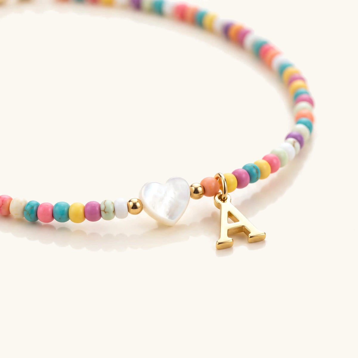 Close-up of colorful beads and gold initial on the beaded choker