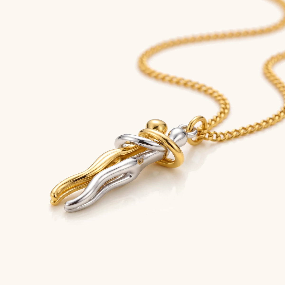 Close-up of the interlocking hug pendant in gold and silver