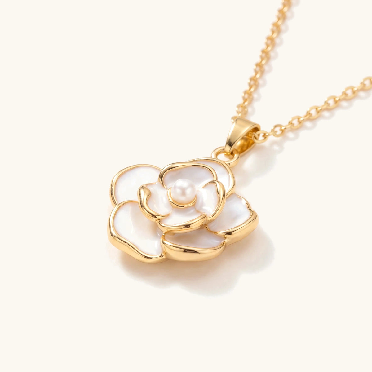 Close-up of the white camellia pendant with pearl centre and gold-edged petals