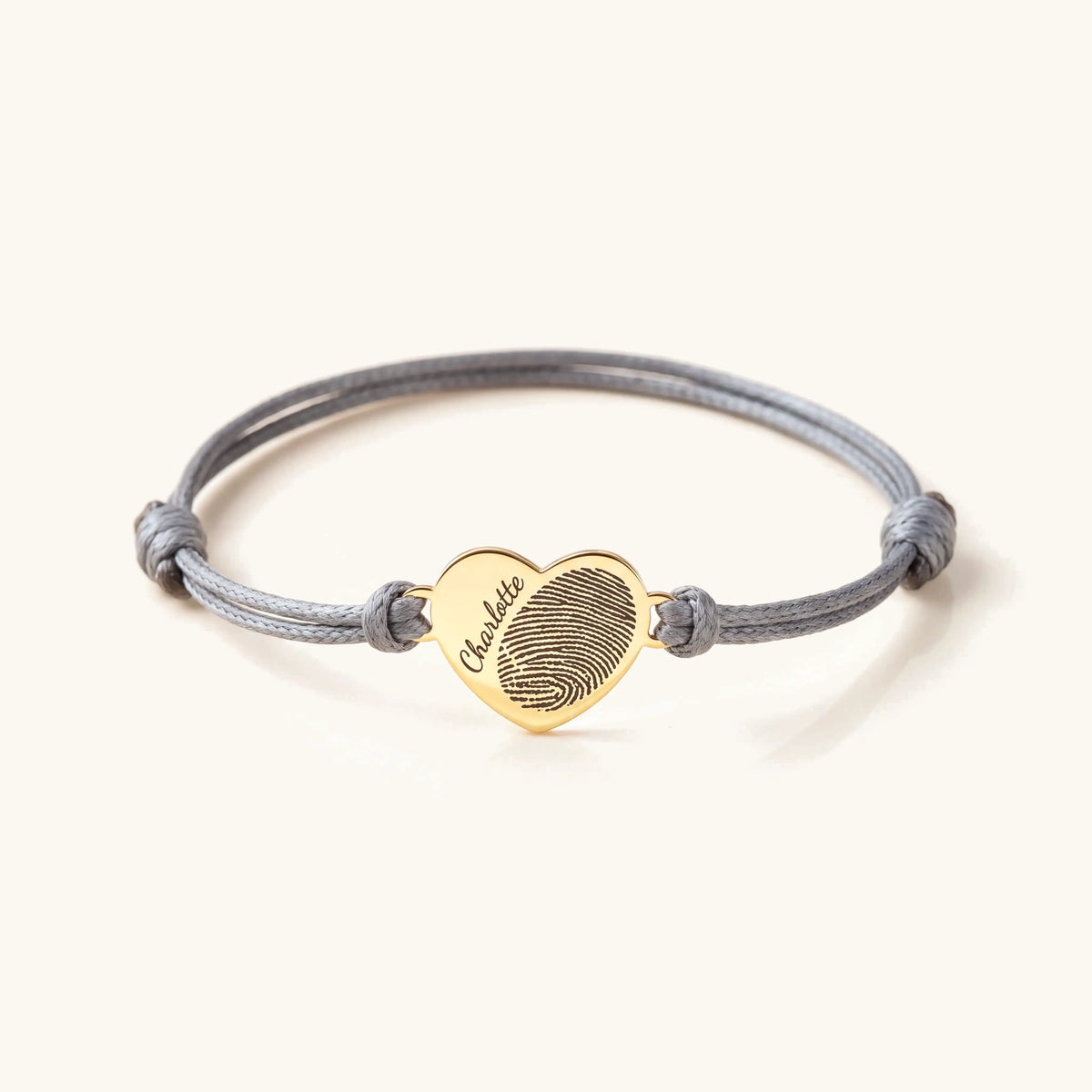 Adjustable custom heart name and fingerprint rope bracelet with gold heart charm on grey cord