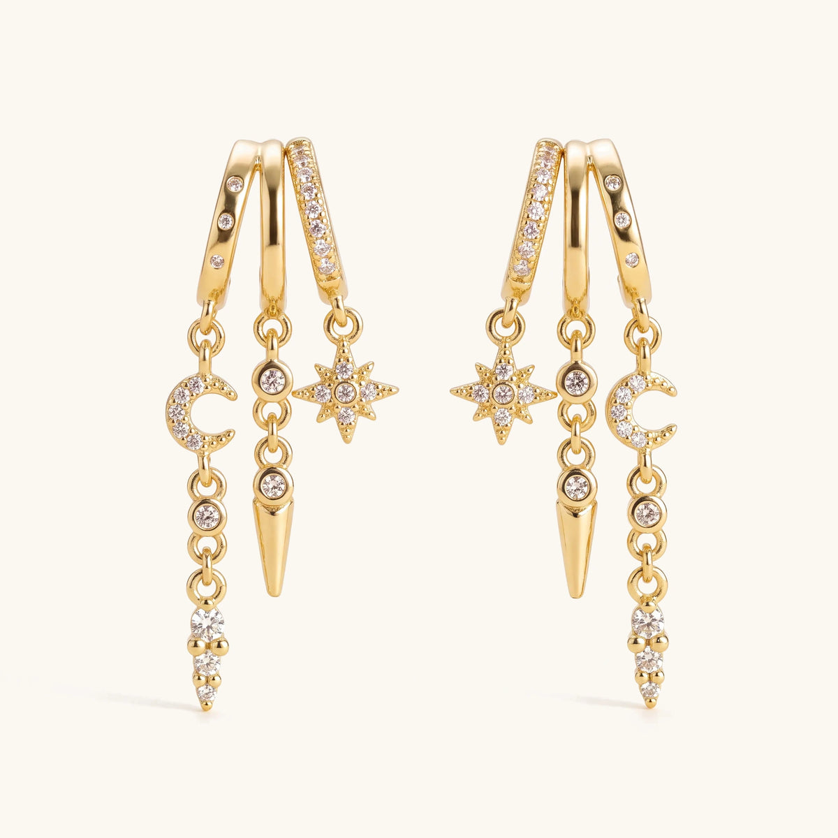 14k Triple Huggie Dangle Earrings Pair – gold huggie hoops with dangling charms on a soft ivory background