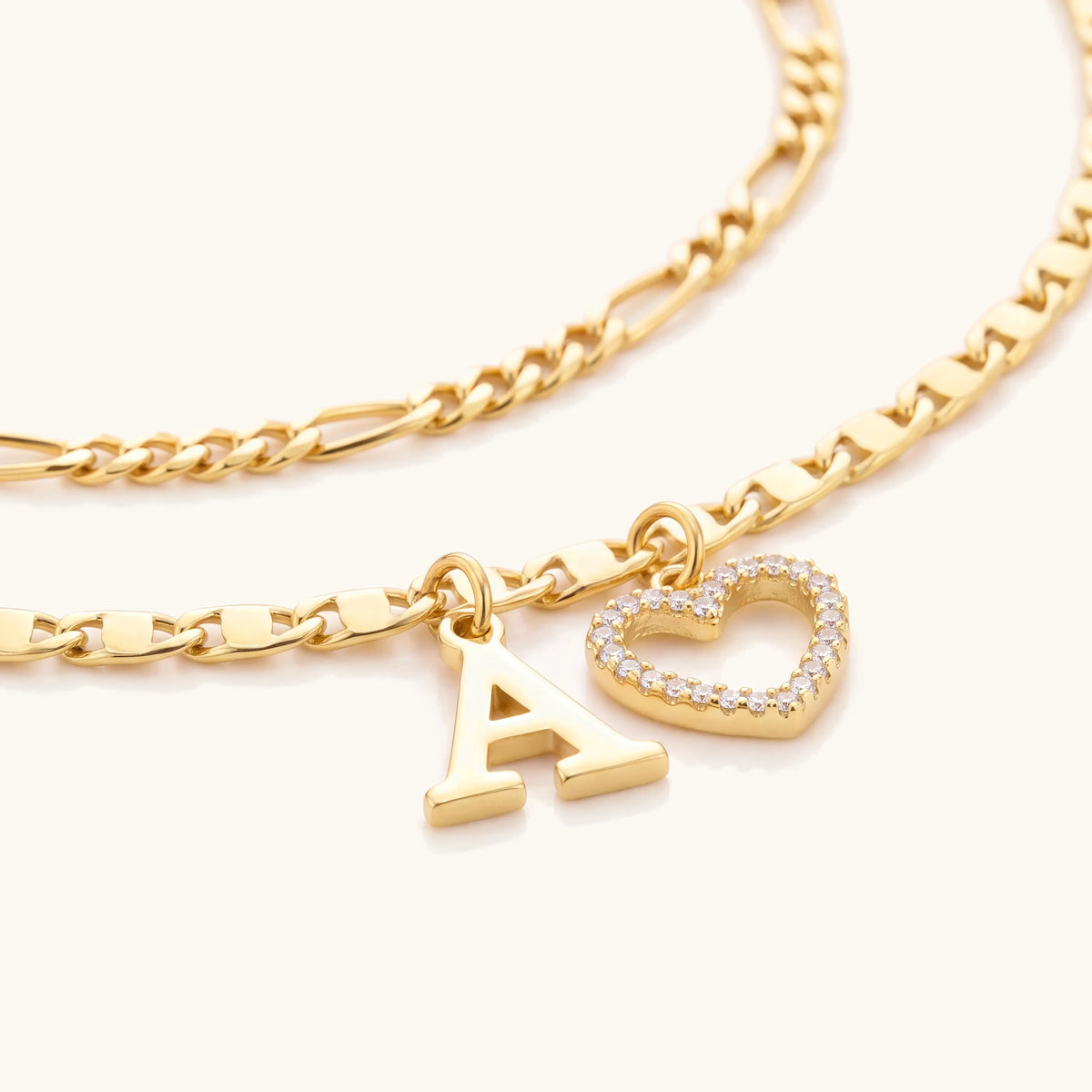 Close-up of the gold letter A charm and crystal heart charm on the anklet