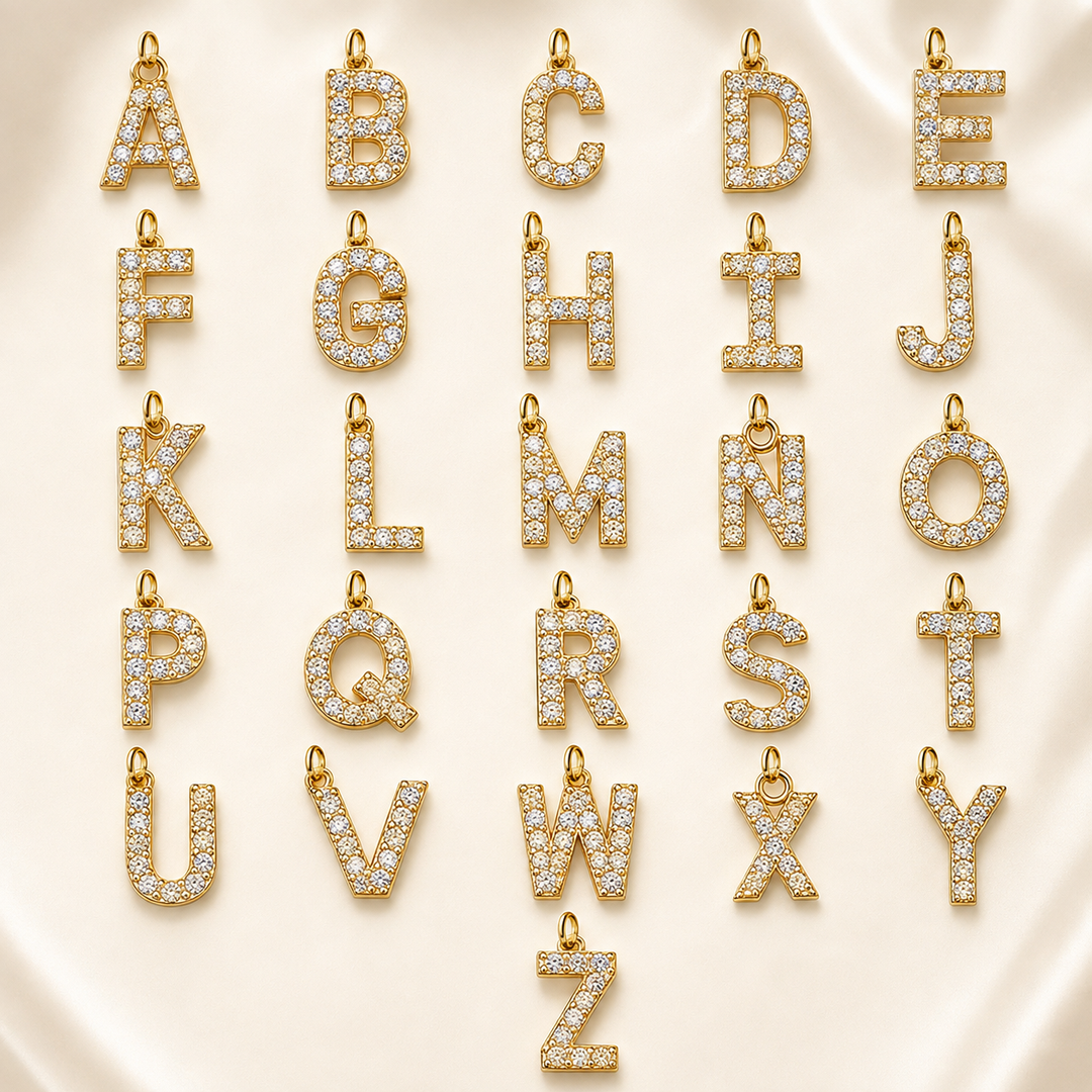 Dainty Diamond Letter Initial Lariat Necklace gold A to Y alphabet pendant charms with clear rhinestones arranged on cream satin.