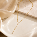 Load image into Gallery viewer, Dainty Diamond Letter Initial Lariat Necklace delicate gold Y-necklace with open heart and dangling A charm on a white ceramic plate.
