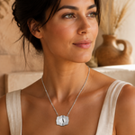 Load image into Gallery viewer, Dainty Belt Buckle Letter Initial Necklaces woman wearing a silver pendant necklace with a textured shield-shaped pendant and beige linen top indoors.
