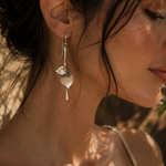 Load image into Gallery viewer, Elegant Vintage Drop Earrings in Silver close-up side profile of a woman wearing a silver dangle earring with a leaf-shaped charm and teardrop detail against a sunlit outdoor background.
