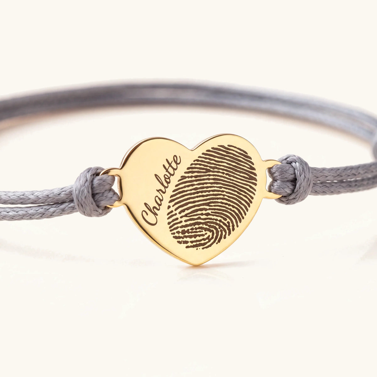 Close-up of the engraved gold heart charm on the fingerprint rope bracelet