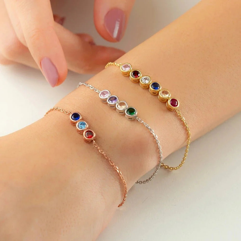 Dainty birthstones chain bracelet two colorful gemstone bracelets worn on a wrist against a neutral background