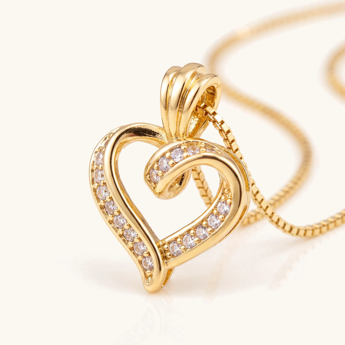 Close-up of the gold heart pendant showing its stone setting