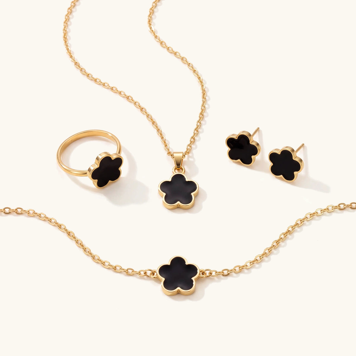 Dainty lucky floral clover jewellery set in gold with black flowers: necklace, bracelet, ring and stud earrings
