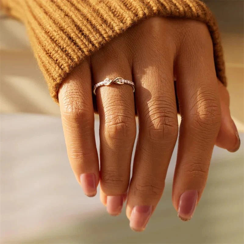 Forever infinity diamond ring worn on a hand with a blurred background showcasing an elegant diamond ring