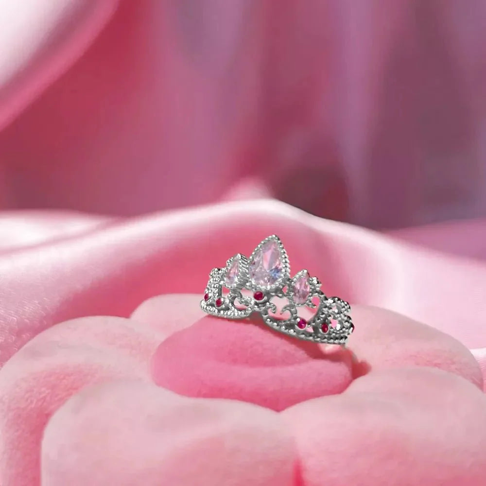 Rapunzel Crown Inspired Necklaces and Rings dainty tiara-shaped ring displayed on a pink fabric background.